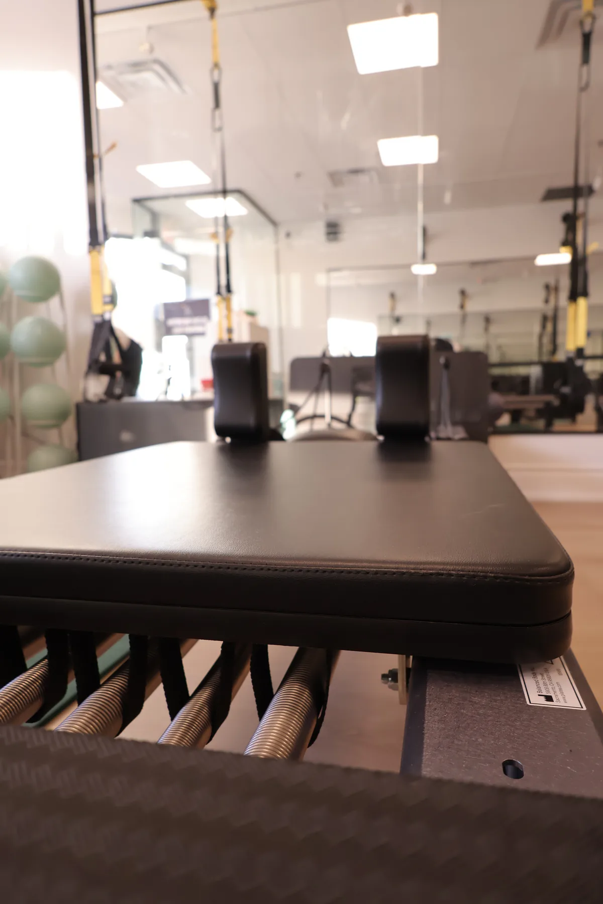 Pilates reformer with carriage, springs, and footbar at Motion Vitality Pilates.