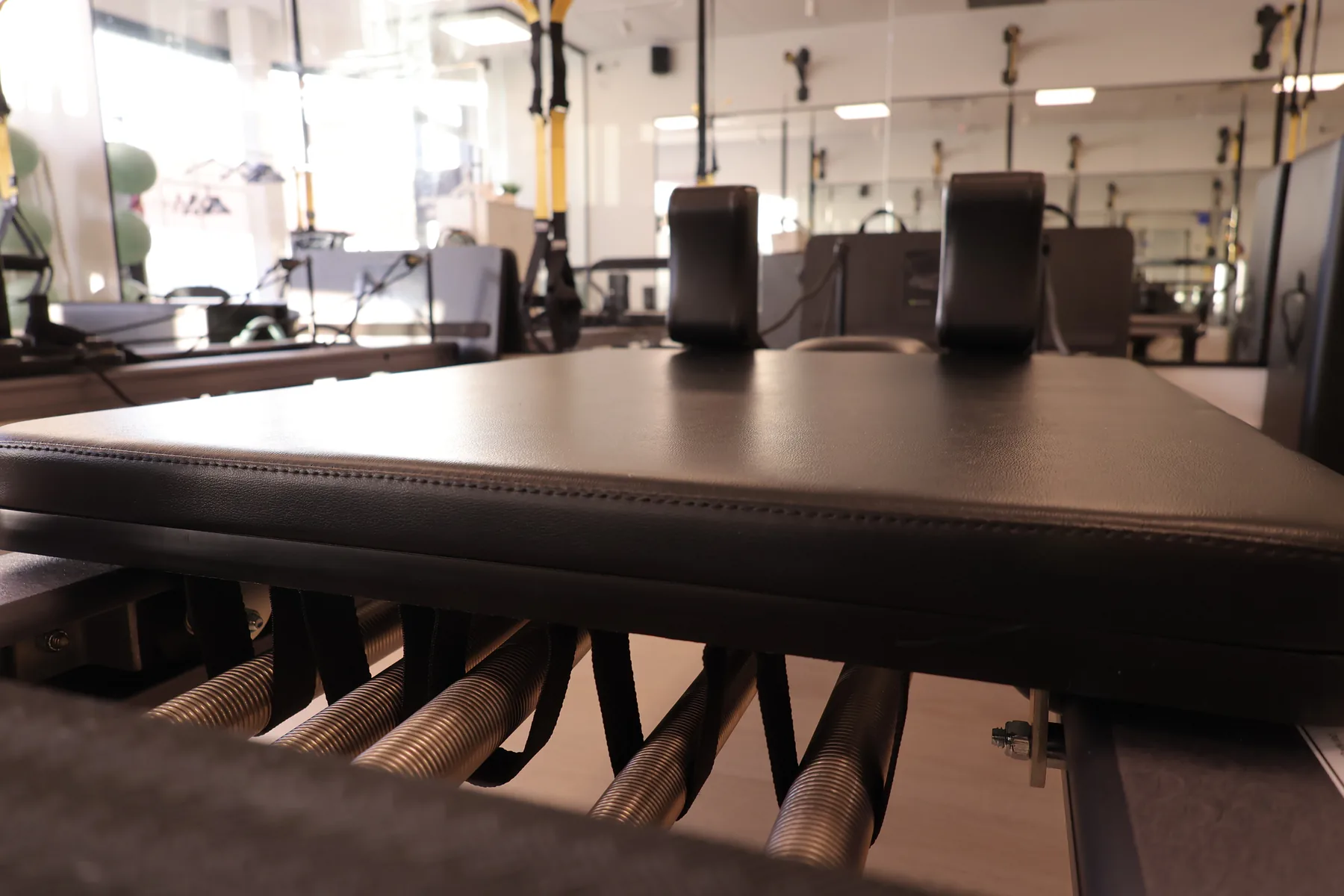 Wide view of a Pilates reformer in the mirrored group studio.