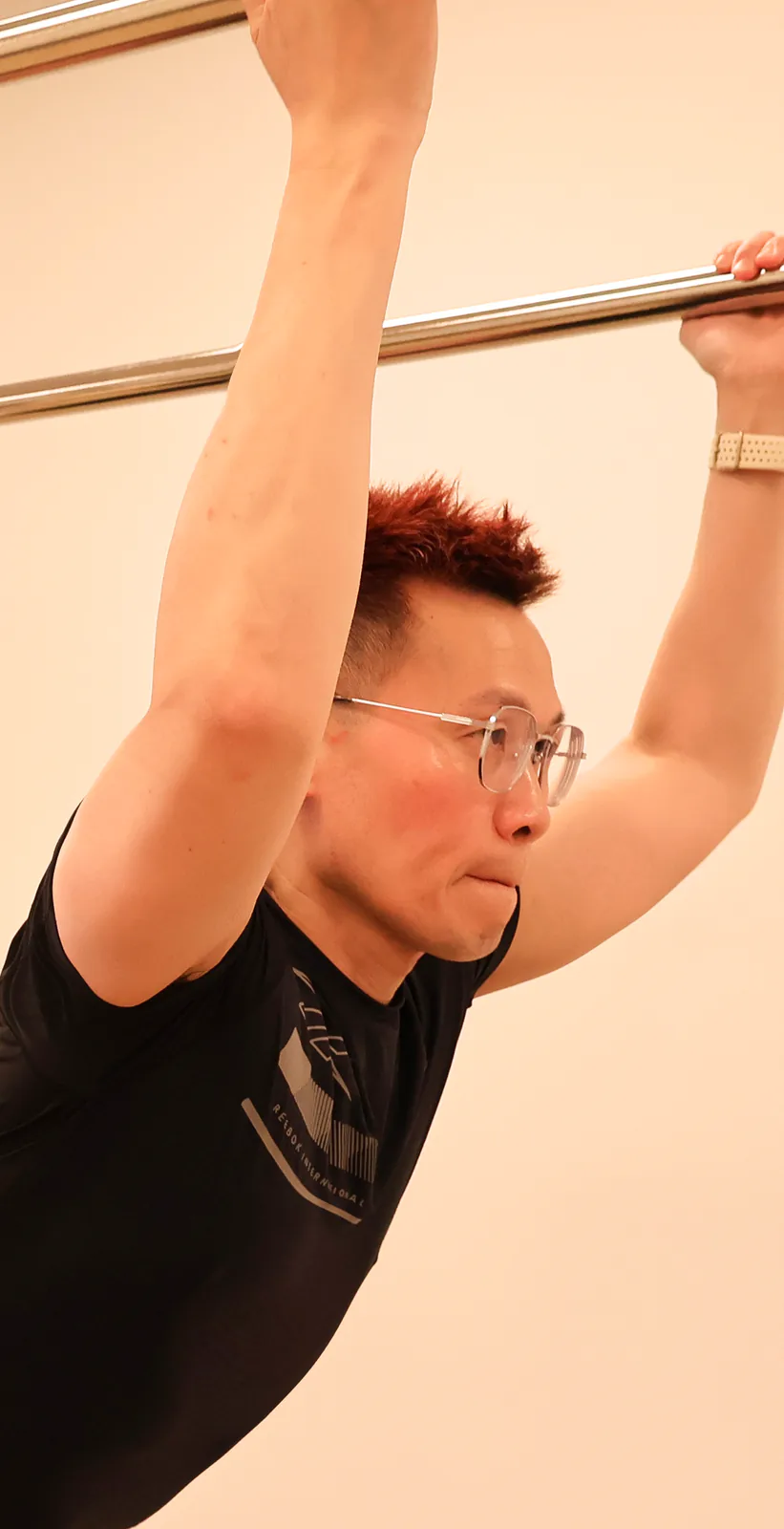 Gary Fok demonstrating a Pilates movement at Motion Vitality Pilates.